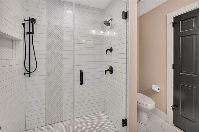 bathroom featuring tile patterned floors, toilet, and walk in shower