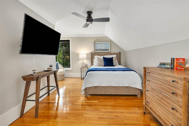 bedroom with ceiling fan, light hardwood / wood-style floors, and vaulted ceiling