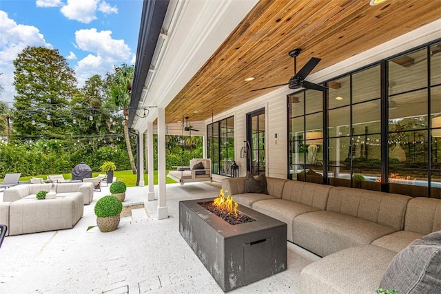 view of patio / terrace featuring ceiling fan and an outdoor living space with a fire pit