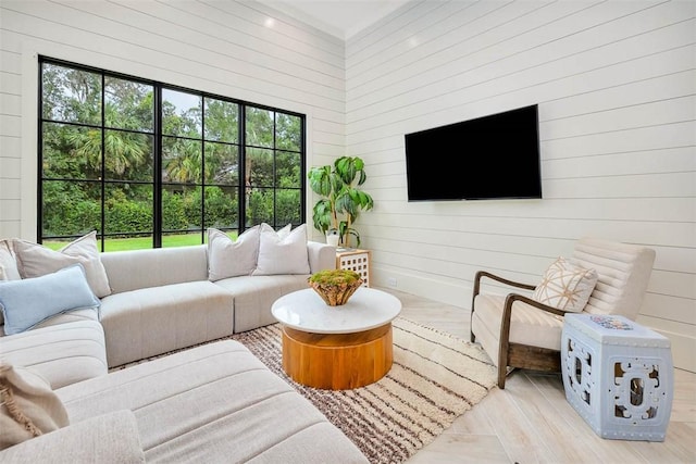 living room featuring wood walls, a healthy amount of sunlight, and light hardwood / wood-style flooring