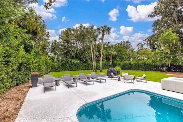 view of pool featuring a lawn and a patio area