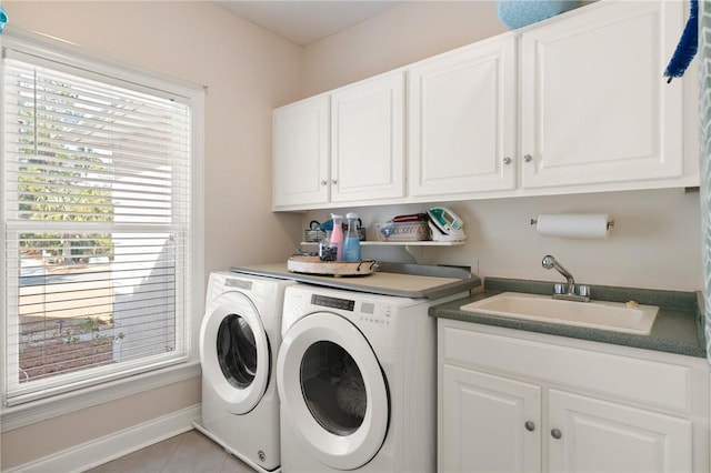 laundry area with cabinets, light tile patterned flooring, separate washer and dryer, and sink