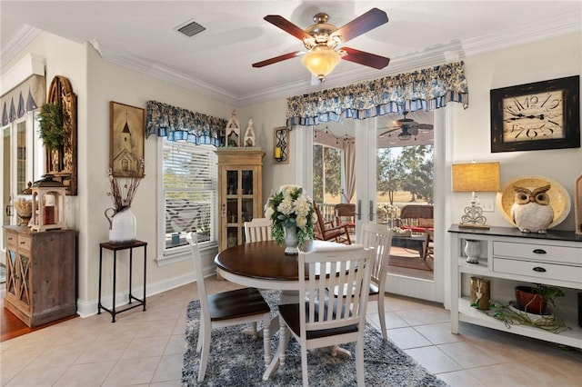 tiled dining room with ornamental molding, french doors, and ceiling fan