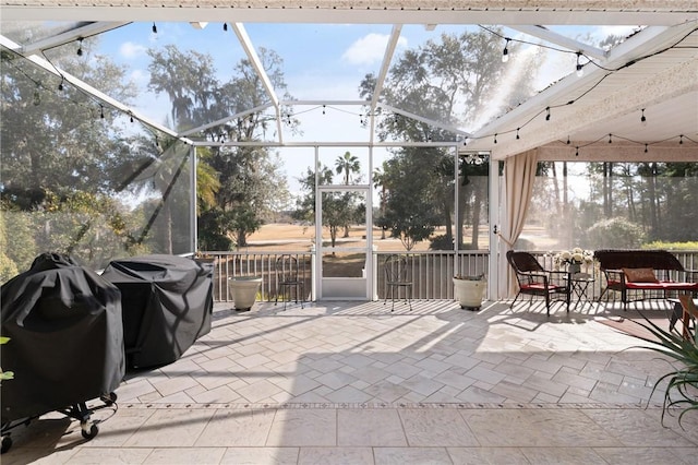 view of patio with a grill and glass enclosure