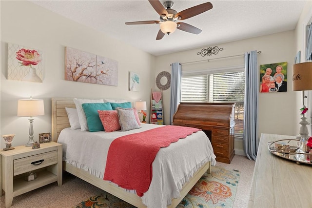 carpeted bedroom with ceiling fan and a textured ceiling