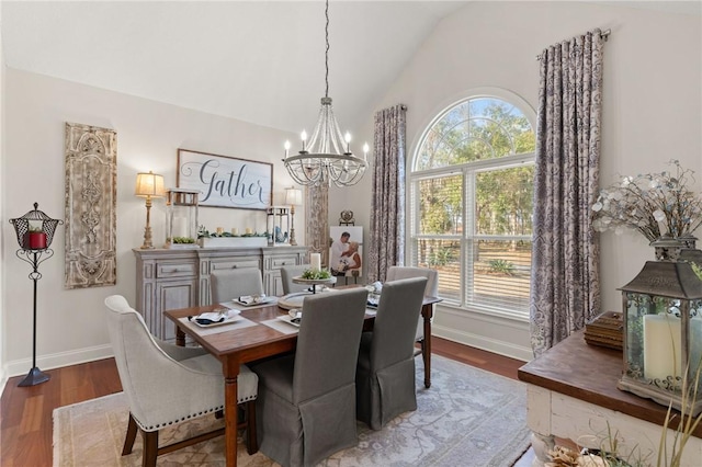 dining room featuring hardwood / wood-style flooring, an inviting chandelier, and vaulted ceiling