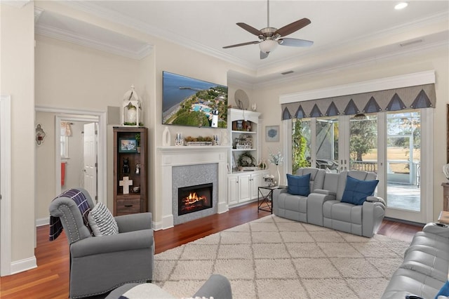 living room featuring crown molding, a fireplace, and hardwood / wood-style floors