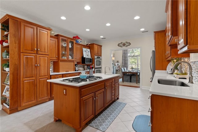 kitchen with sink, decorative backsplash, ornamental molding, a center island, and stainless steel appliances