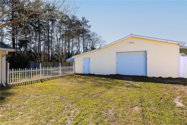 detached garage featuring driveway and fence