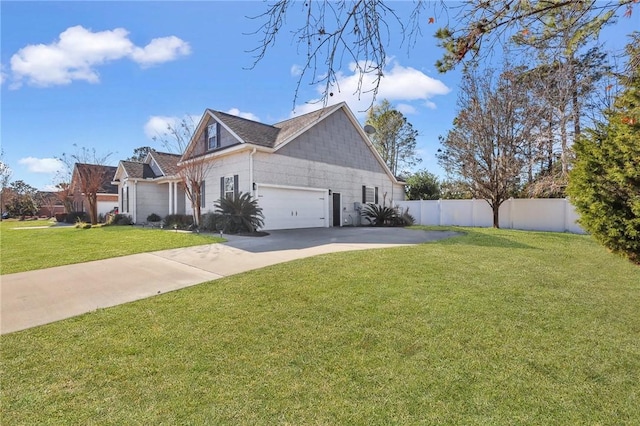 view of side of property with concrete driveway, a yard, and fence