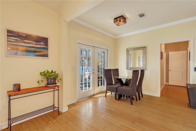 sitting room with french doors, visible vents, light wood-style flooring, and crown molding