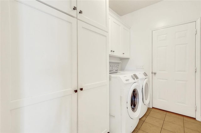 washroom featuring light tile patterned floors, cabinet space, and independent washer and dryer