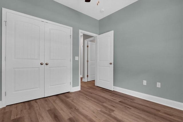 unfurnished bedroom with ceiling fan, a closet, and light hardwood / wood-style floors