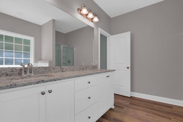 bathroom featuring a shower with door, vanity, and wood-type flooring