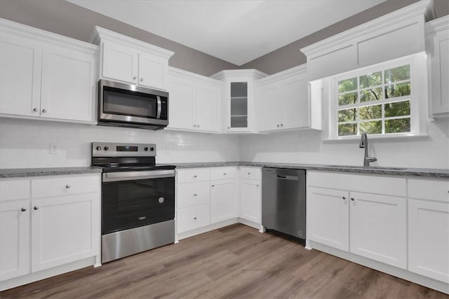 kitchen featuring white cabinets, appliances with stainless steel finishes, hardwood / wood-style flooring, and sink