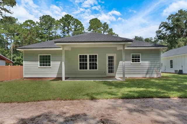 rear view of house featuring a patio, central AC, and a lawn