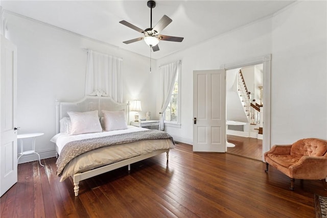 bedroom with ornamental molding, ceiling fan, and dark hardwood / wood-style flooring