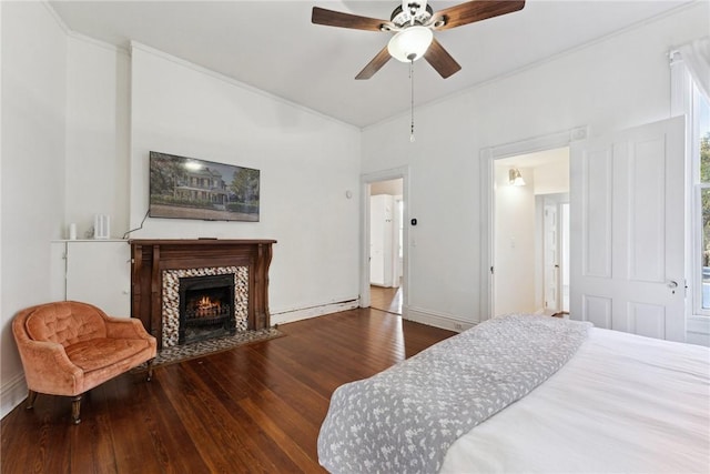 bedroom with ceiling fan, hardwood / wood-style floors, and a baseboard heating unit