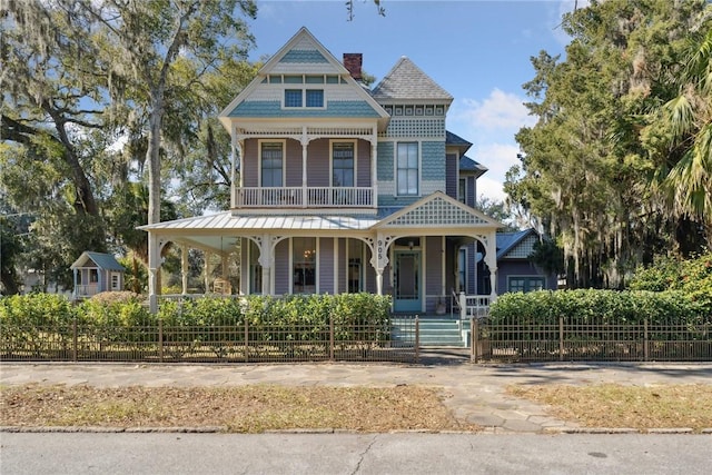 victorian home featuring a balcony and covered porch