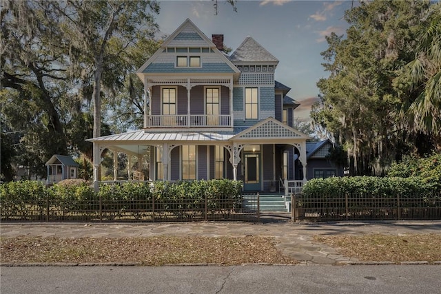 victorian house featuring covered porch and a balcony