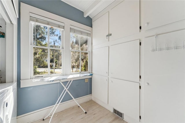 interior space featuring cabinets, a healthy amount of sunlight, light hardwood / wood-style flooring, and washing machine and dryer