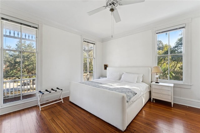 bedroom with ceiling fan, dark wood-type flooring, and multiple windows