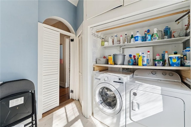 clothes washing area with heating unit, light hardwood / wood-style flooring, and independent washer and dryer