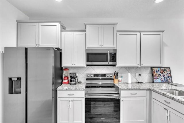 592 Brightleaf Cir, Hinesville, GA 31313 - kitchen featuring appliances with stainless steel finishes, tasteful backsplash, light stone countertops, and recessed lighting