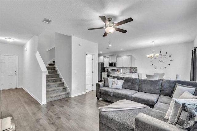 592 Brightleaf Cir, Hinesville, GA 31313 - living area with a chandelier, ceiling fan, stairway, light wood-type flooring, and baseboards