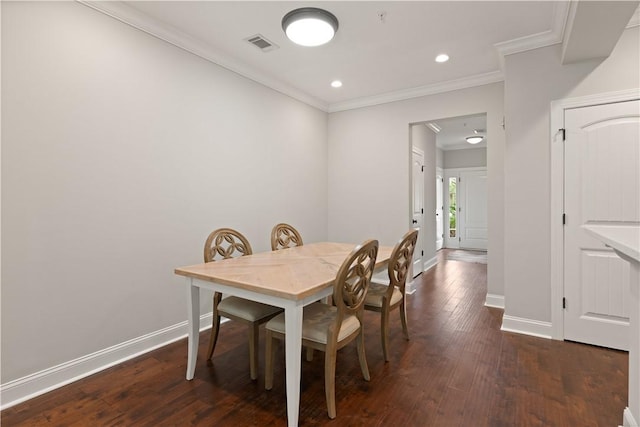 dining area with dark hardwood / wood-style flooring and crown molding