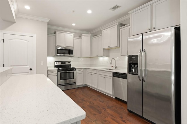 kitchen featuring backsplash, sink, appliances with stainless steel finishes, and dark wood-type flooring