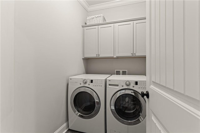 washroom with crown molding, washer and clothes dryer, and cabinets