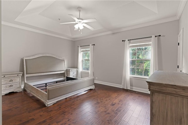 unfurnished bedroom with ceiling fan, dark hardwood / wood-style floors, crown molding, and a tray ceiling