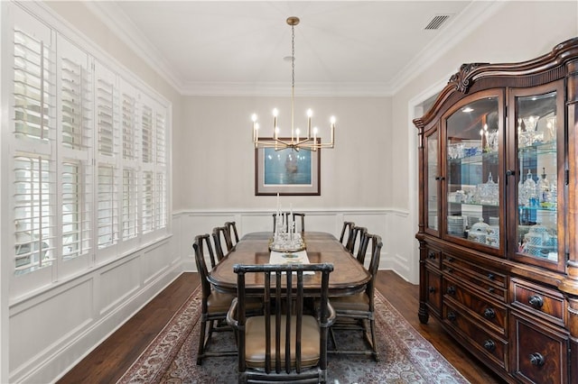 dining area with a notable chandelier, crown molding, and dark wood-type flooring