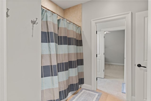 bathroom with curtained shower and tile patterned floors