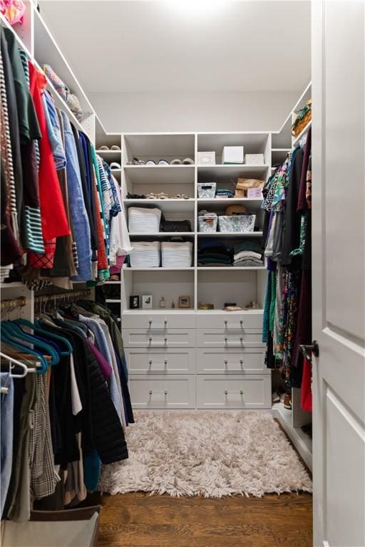 walk in closet with dark wood-type flooring