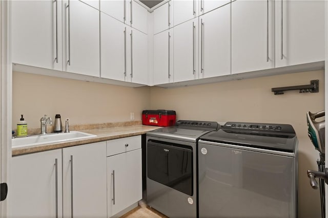 clothes washing area with cabinets, sink, and washing machine and dryer