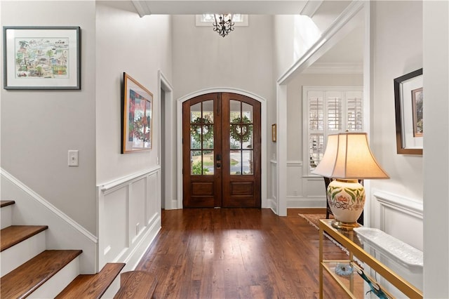 entrance foyer with dark wood-type flooring, an inviting chandelier, and french doors