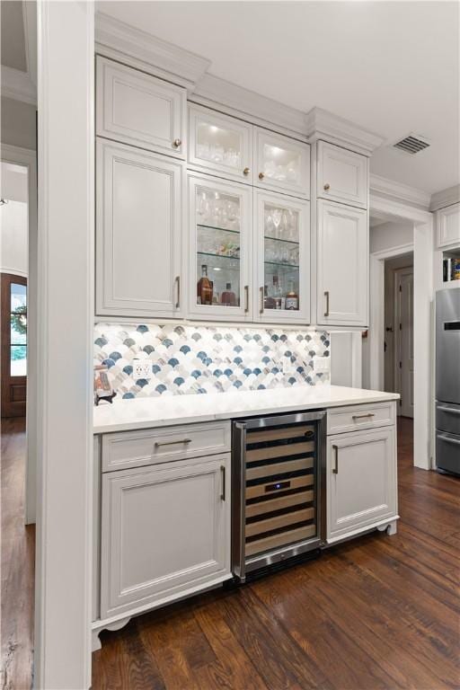 bar with white cabinetry, stainless steel fridge, dark wood-type flooring, and wine cooler