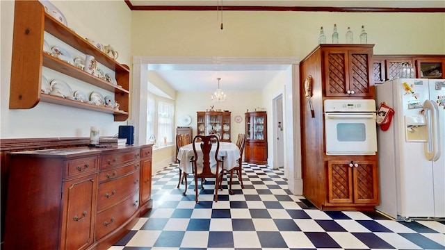 kitchen with a notable chandelier, open shelves, tile patterned floors, white appliances, and dark countertops