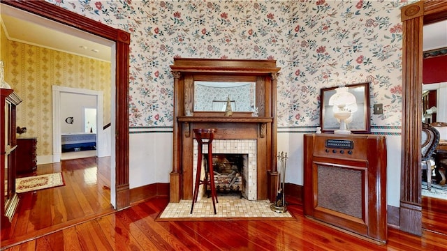 interior space featuring hardwood / wood-style floors, wallpapered walls, and wainscoting