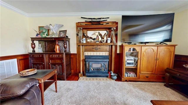 sitting room with visible vents, wainscoting, a fireplace, and crown molding