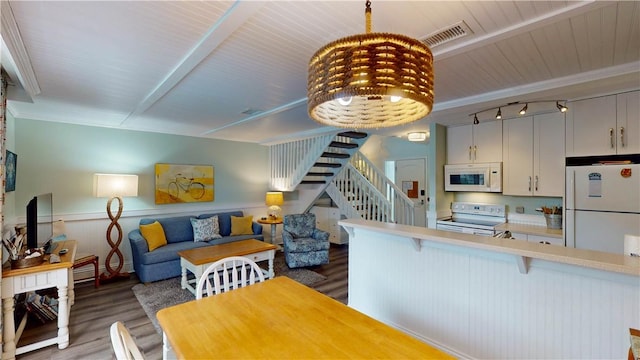 kitchen with a breakfast bar area, light countertops, visible vents, open floor plan, and white appliances