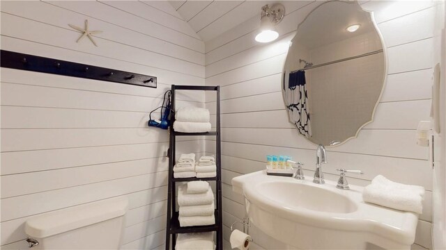 bathroom featuring curtained shower and toilet