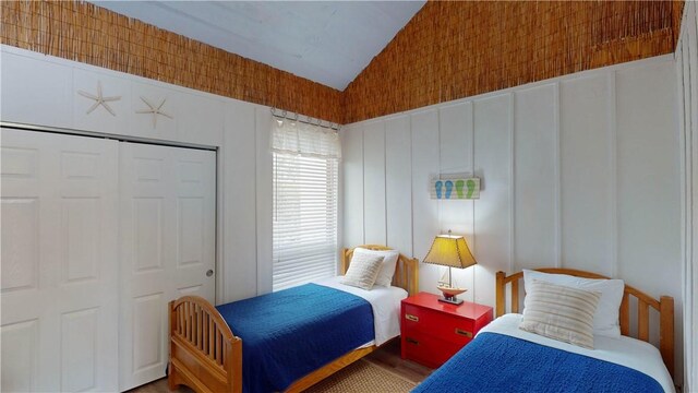 bedroom featuring lofted ceiling, a closet, and wood finished floors