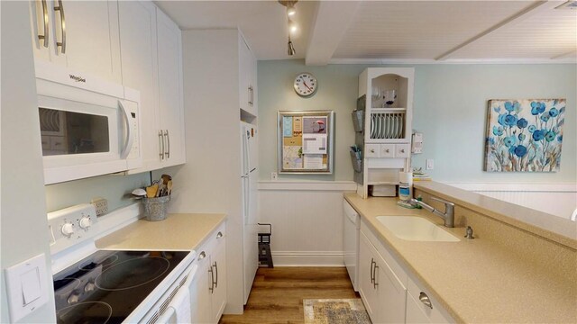 kitchen featuring white appliances, a sink, white cabinetry, light countertops, and light wood-type flooring