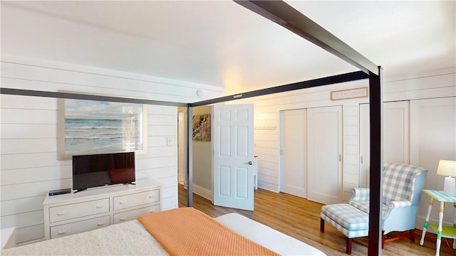 1175 N Beachview Dr Unit 337, Jekyll Island, GA 31527 - bedroom featuring wooden walls, multiple closets, and light wood finished floors