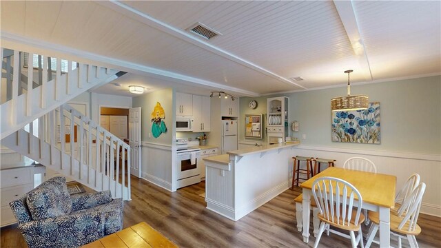 kitchen featuring a peninsula, white appliances, visible vents, white cabinets, and light countertops