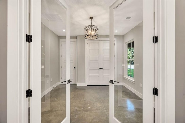 interior space with concrete floors and an inviting chandelier