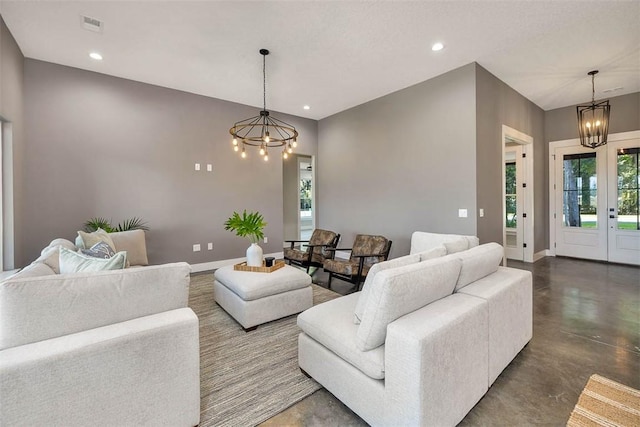 living room with concrete flooring and a chandelier